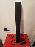 Full view of soundbar with remote, power adapter and cable laid out