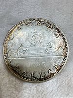 Reverse of 1965 Canada silver dollar showing canoe design and date