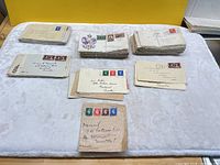 Overview showing multiple twine-tied stacks of vintage envelopes on table