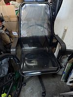 Full front view of black steel perforated office chair with armrests and swivel caster base