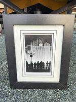 Front view of framed black & white photograph showing image, mat, and frame condition