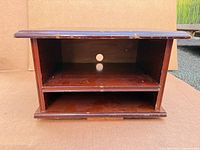 Front view showing shelf opening, adjustable shelf, cable hole, finish color and wear