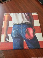 Front album cover with flag background and jeans image