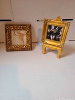 Both framed prints side by side, showing overall size and ornate gold frames