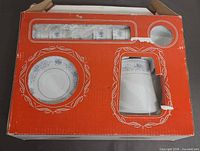 sealed red box showing saucer and cup through cut-outs