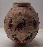 Front view of vessel showing textured surface, bird motifs and rim wrap