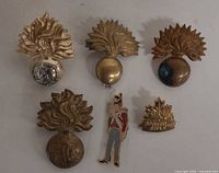 All six badges and pins laid out