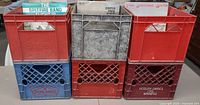 Front view of six stacked plastic milk crates with vinyl records visible