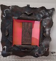 Full view of metal wall art showing frame, pink backing, and cityscape plaque