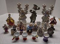 Group shot showing entire lot of figurines, candlesticks, egg cups and decorative pieces