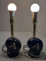 Front view showing both lamps lit with bulbs, helmet fronts with A logo