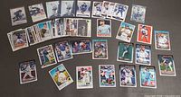 Overview of entire lot of 40+ baseball and hockey cards laid out on surface