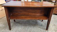 Front view of mahogany writing desk showing open shelf and legs