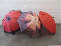 Three umbrellas closed and partially open showing canopy designs