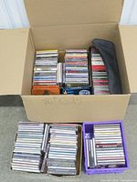 Large cardboard box with CDs and accessories visible