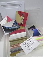 Stacked assorted Papyrus greeting cards and envelopes in plastic bins, several designs visible