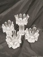 Four clear glass Sunflower candle holders arranged upright; height differences visible