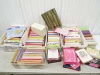 Six plastic bins filled with stacked greeting cards, envelopes and pads