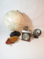 All items together: globe, Selangor clock, two eyeball lamps, two pewter leaf dishes