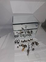 Overall view of mirrored glass jewelry box with jewelry pieces displayed