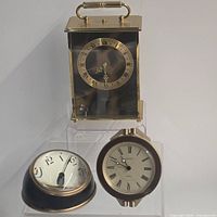 Group shot of Helveco carriage clock, Seiko travel alarm, Pottery Barn desk clock
