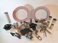 All items in lot: plates, knives, spice tins, mills, utensils