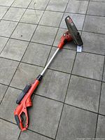 Full view of Black & Decker GH710 string trimmer lying on tiled surface