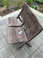 Front angle of two-seat folding wooden chair showing slatted seats, backs, and missing slats