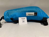 Blue Baggy McBag lounger folded in pouch with logo patch visible