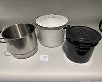 Three canning pots side-by-side, showing materials, lids, and exterior condition