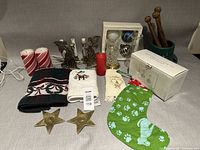 Group shot of entire lot including candles, candle holders, ornaments, jar, towels, stocking, crock with wooden utensils and boxed candle holder