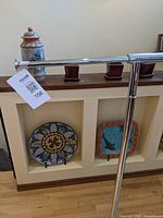 Top rail and upright post of chrome clothes rack with lot tag visible