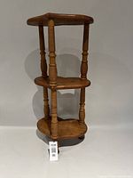 Three-tier wooden end table showing overall form and shelves