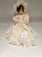 Full front view of doll standing, showing entire gown and size reference tag