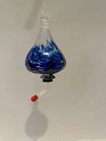 Feeder hanging front view showing shape, color, feeding tube