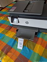 Front-angle view showing HP OfficeJet 8015e printer with output tray extended and scanner lid