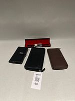Overall lot view with three wallets and Ronald McDonald watch in red presentation case