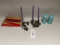 Group shot: metal ivy candle holder with purple tapers, decorative taper candle box, blue pillar candles