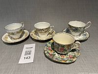 Four distinct teacup and saucer sets displayed