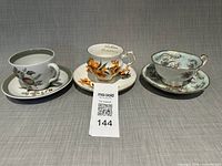 Front view of three teacup and saucer sets side by side