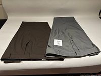 Both pairs of folded pants, brown Dockers left, grey Haggar right