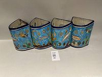 All four ceramic sconces side by side showing overall form and artwork