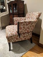Left side view showing floral upholstery, armrests and wooden legs