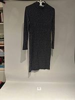 Full view of dress hanging against backdrop