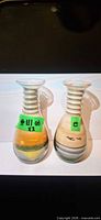 Two clear glass sand art bottles on white backdrop