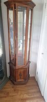 Full view of hexagonal wooden curio cabinet with glass panels and lower compartment