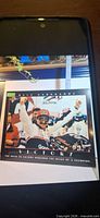 Front of poster showing Dale Earnhardt Sr celebration image and printed Victory caption