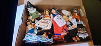 Open box showing first group of dolls in various ethnic costumes