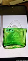 Front view of green art glass purse showing clear handles and body