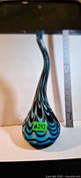 Full view of vase showing bulb base, twisted neck, striped pattern, height reference with ruler